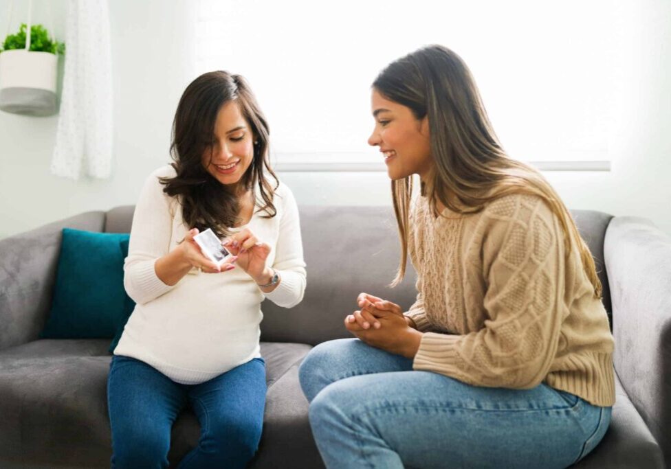 Cheerful,Pregnant,Woman,And,Smiling,Midwife,Looking,At,The,Print Cheerful,Pregnant,Woman,And,Smiling,Midwife,Looking,At,The,Print